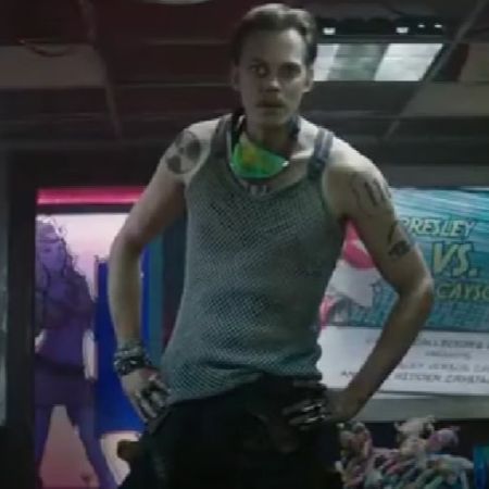 Bill Skarsgård is standing with his hands on his hips.